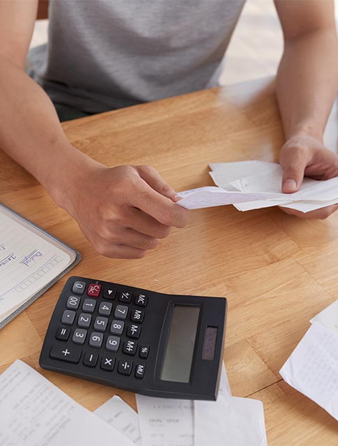 man counting bills with calculator
