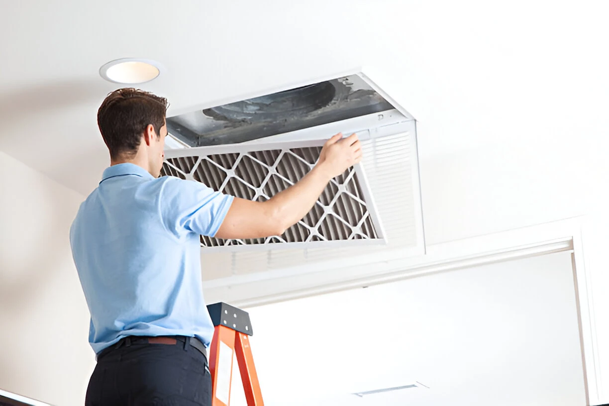 Contractor removing a filter before cleaning an air duct