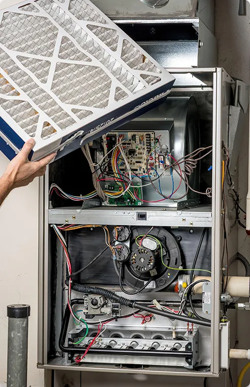 Man replacing or removing a filter on a furnace