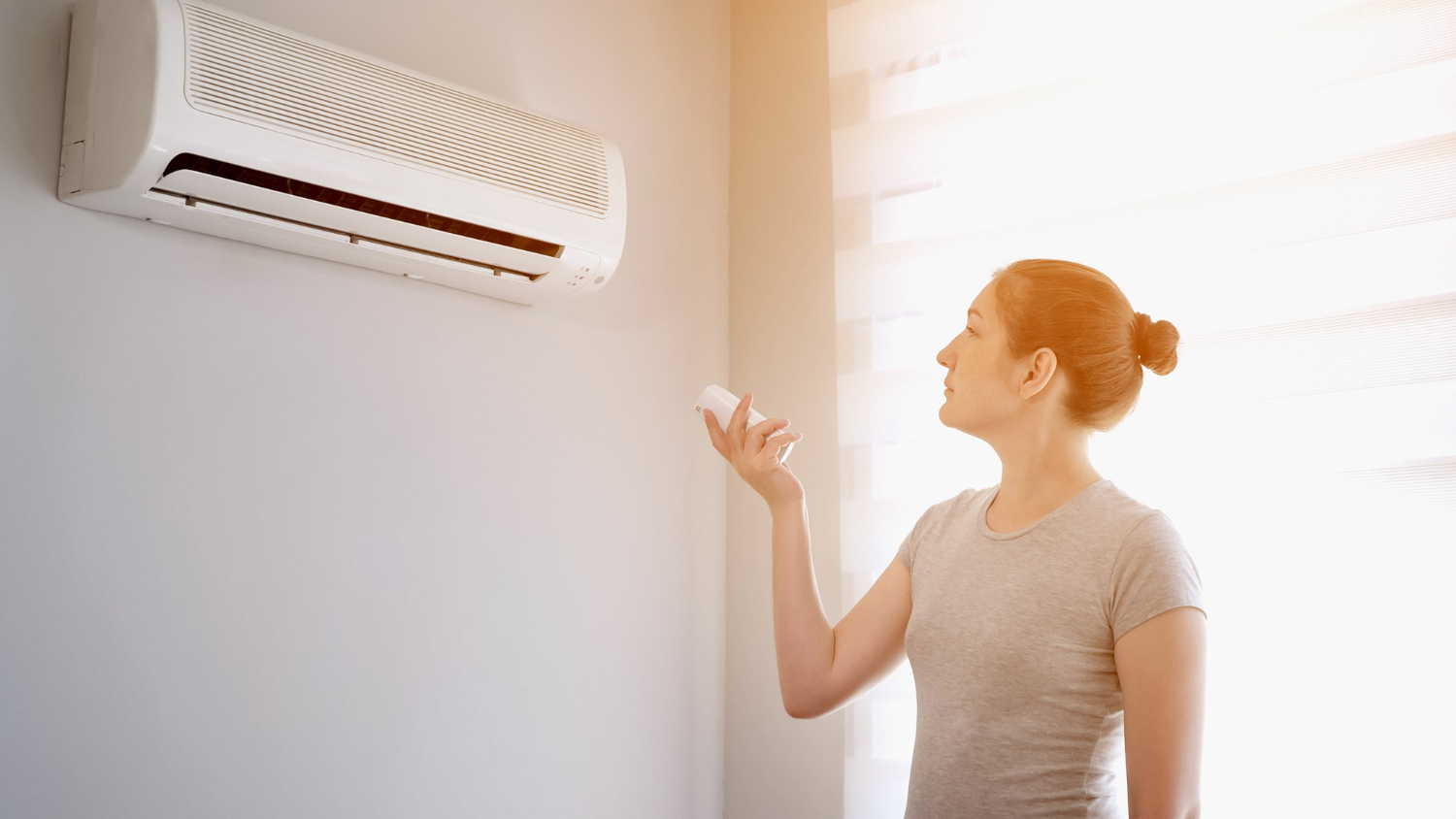 woman turning on air conditioner